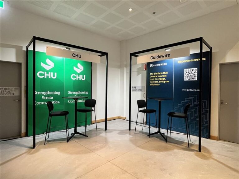 Two exhibit booths with black frames: left CHU green banners and chairs, right Guidewire blue panels with stools and signage.